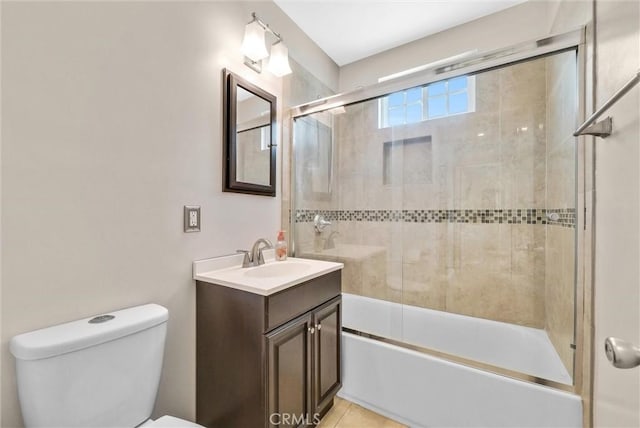 full bathroom featuring tile patterned flooring, vanity, toilet, and bath / shower combo with glass door