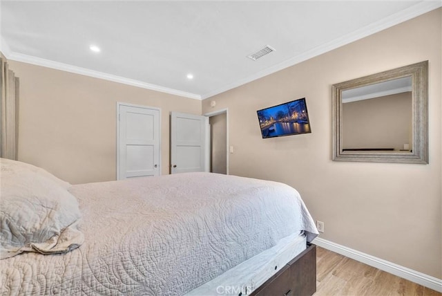 bedroom featuring light hardwood / wood-style floors and crown molding