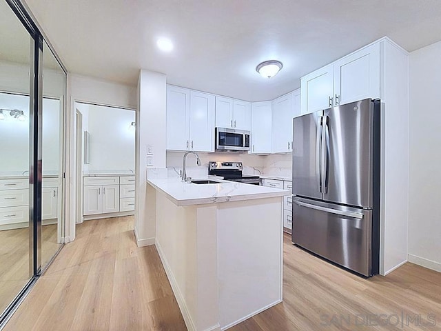 kitchen featuring white cabinetry, sink, light hardwood / wood-style flooring, and stainless steel appliances