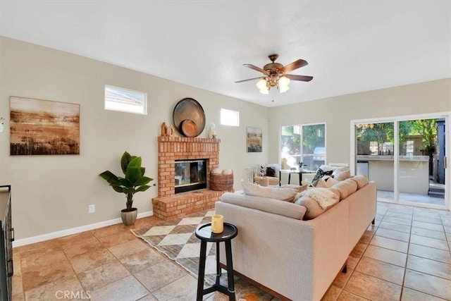 tiled living room with ceiling fan, a healthy amount of sunlight, and a brick fireplace