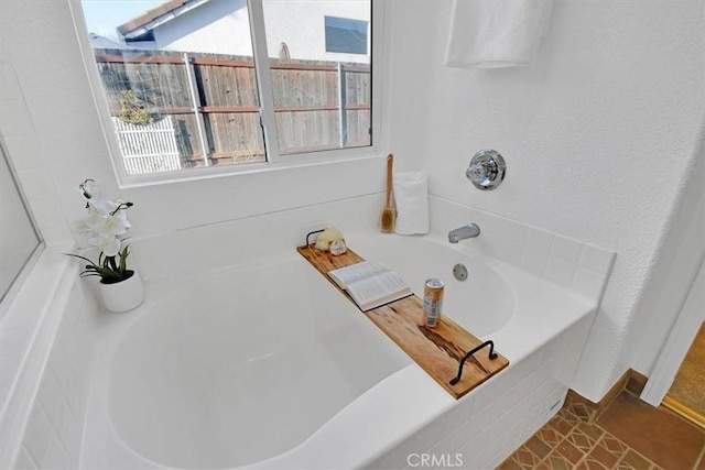 bathroom with tile patterned flooring and a tub