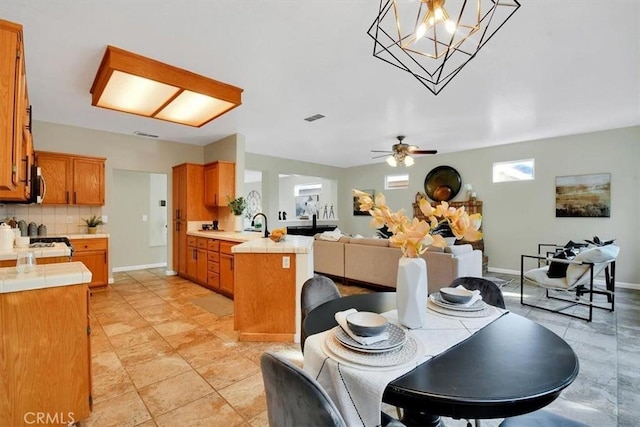 dining area featuring light tile patterned floors and ceiling fan with notable chandelier