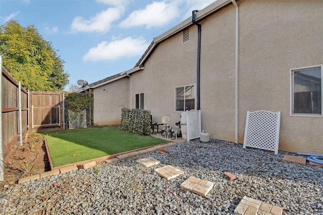 view of side of property with a yard and a patio