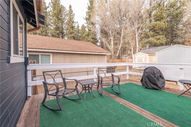 view of patio featuring a grill, a storage shed, and a deck