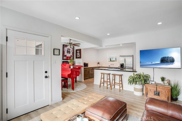 living room with ceiling fan and light wood-type flooring