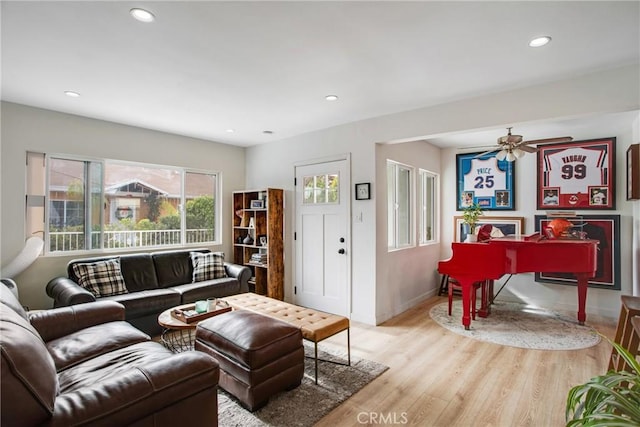 living room with light hardwood / wood-style floors and ceiling fan