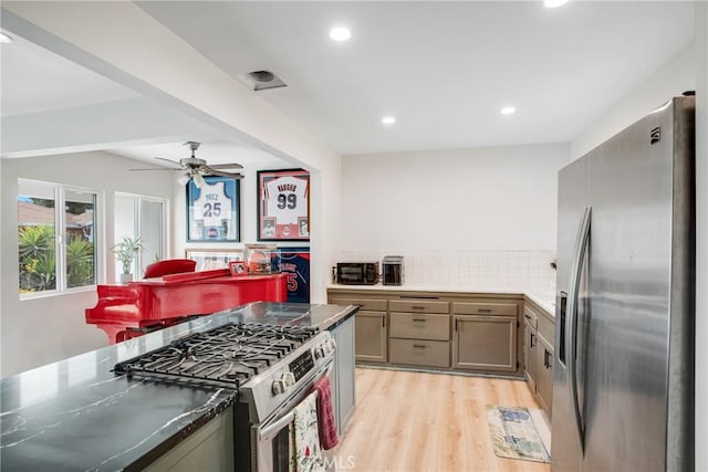 kitchen with decorative backsplash, light hardwood / wood-style floors, stainless steel appliances, and ceiling fan