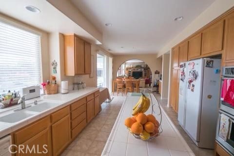 kitchen featuring white appliances, tile counters, a wealth of natural light, and sink