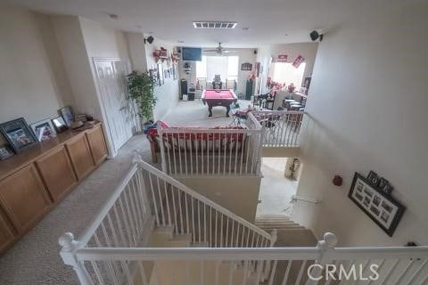 stairway with carpet flooring, ceiling fan, and pool table