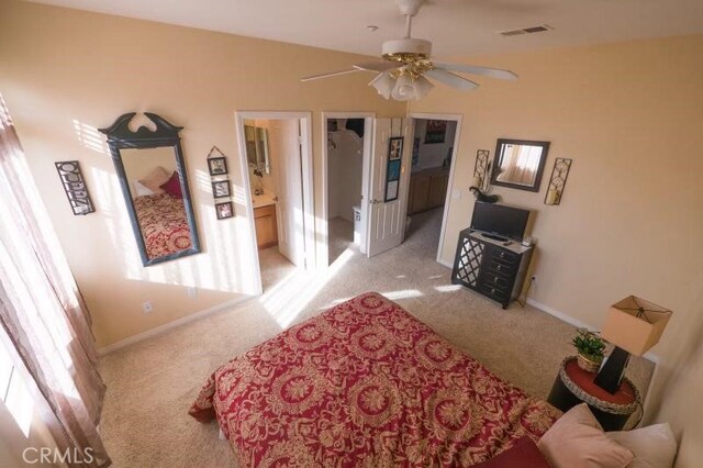 carpeted bedroom featuring ensuite bathroom, ceiling fan, and a spacious closet