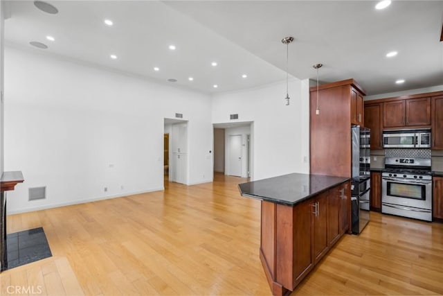 kitchen featuring decorative backsplash, light wood-type flooring, stainless steel appliances, a high ceiling, and hanging light fixtures