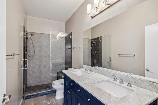 bathroom featuring tile patterned flooring, vanity, an enclosed shower, and toilet