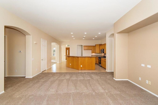 unfurnished living room featuring light colored carpet