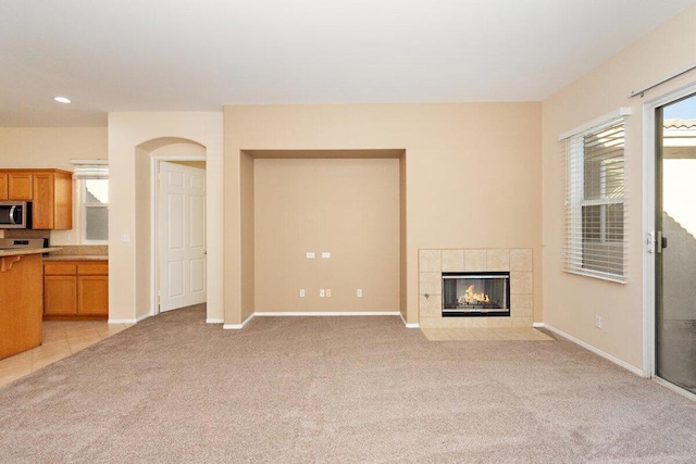 unfurnished living room with light carpet and a fireplace