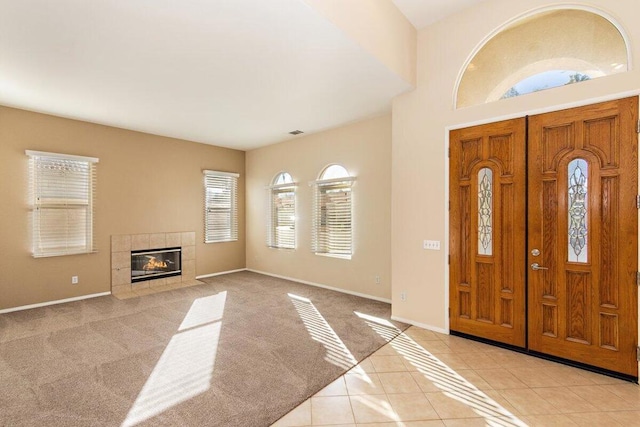 entryway featuring a tile fireplace and light tile patterned floors