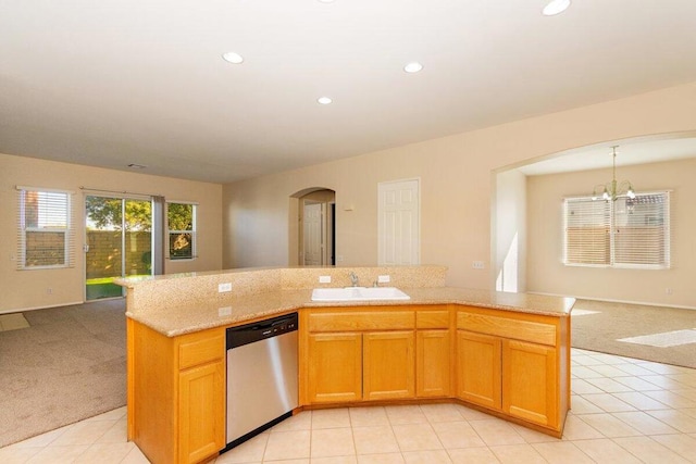 kitchen featuring dishwasher, light colored carpet, sink, and a chandelier