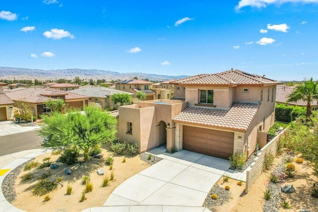 view of front of home with a mountain view and a garage