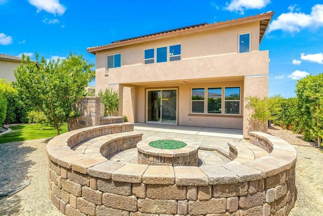 rear view of house featuring an outdoor fire pit and a patio area