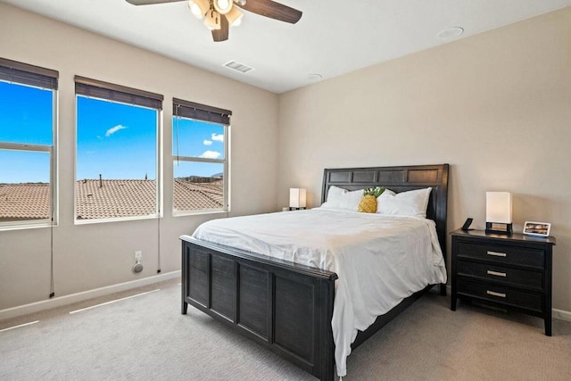 carpeted bedroom featuring multiple windows and ceiling fan