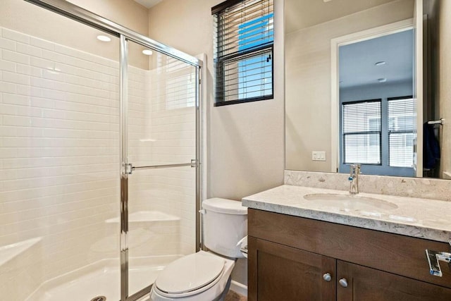 bathroom featuring vanity, toilet, and an enclosed shower