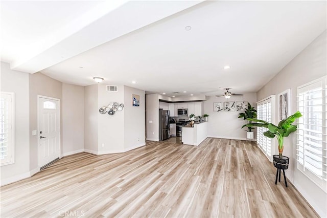 unfurnished living room with ceiling fan, plenty of natural light, and light hardwood / wood-style flooring