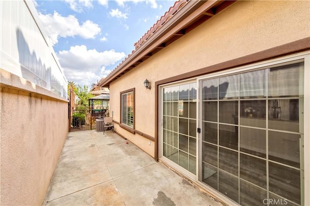 view of side of property featuring a patio and central AC