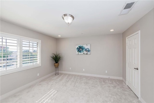 spare room featuring light carpet