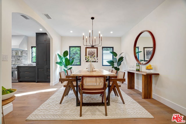 dining area featuring light hardwood / wood-style floors and an inviting chandelier