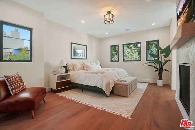 bedroom with hardwood / wood-style flooring, multiple windows, and a notable chandelier