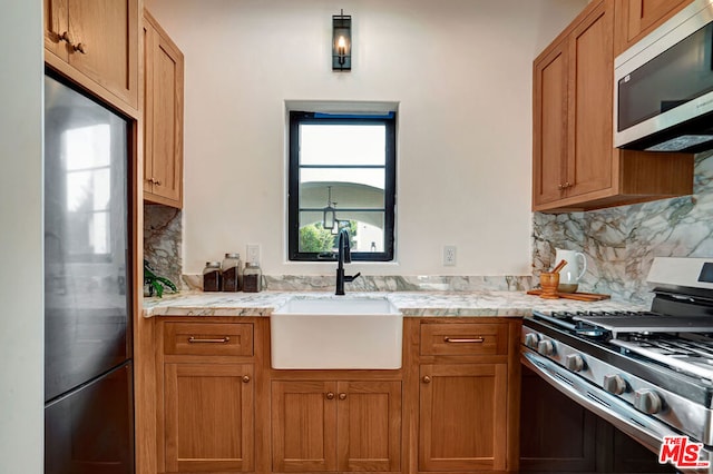 kitchen with appliances with stainless steel finishes, backsplash, and sink