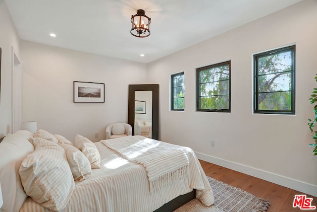 bedroom featuring hardwood / wood-style floors and a notable chandelier