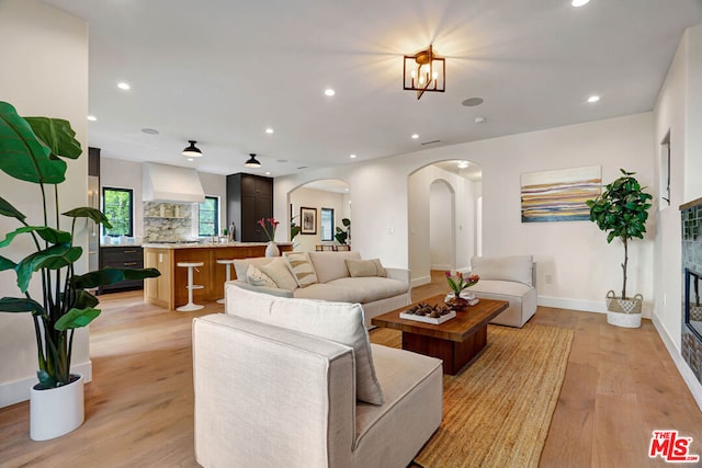 living room with light hardwood / wood-style floors and an inviting chandelier