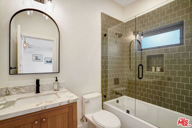 full bathroom with vanity, toilet, and enclosed tub / shower combo