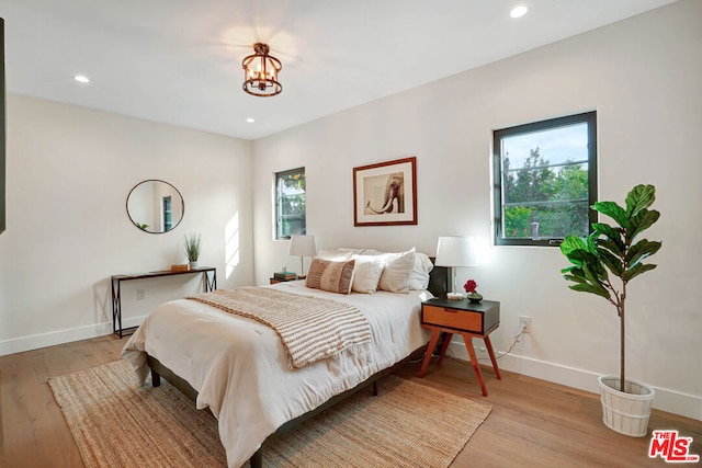 bedroom with a chandelier and light hardwood / wood-style flooring