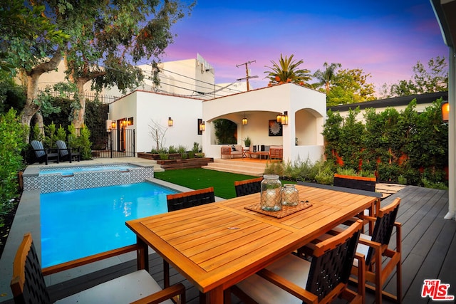 pool at dusk featuring a wooden deck