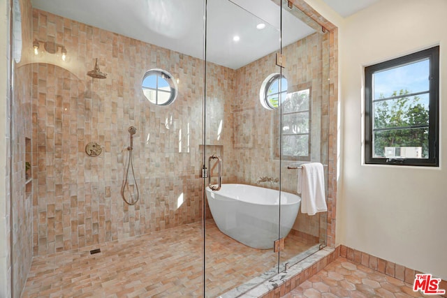 bathroom featuring tile patterned flooring, tile walls, and plus walk in shower