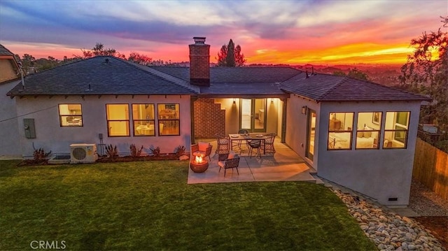 back house at dusk with a patio area, a yard, and ac unit