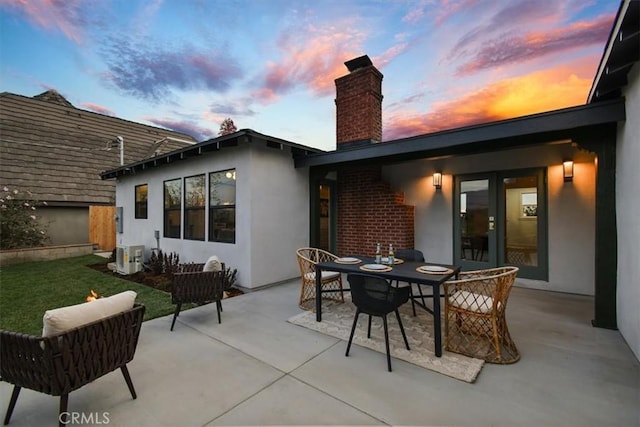 back house at dusk with a patio area