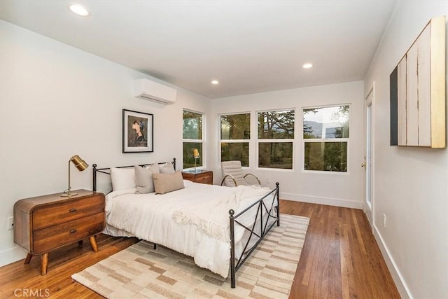 bedroom featuring an AC wall unit and light wood-type flooring