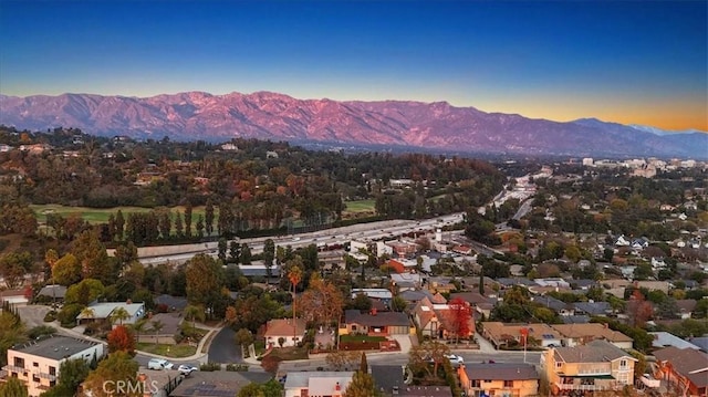 aerial view at dusk featuring a mountain view