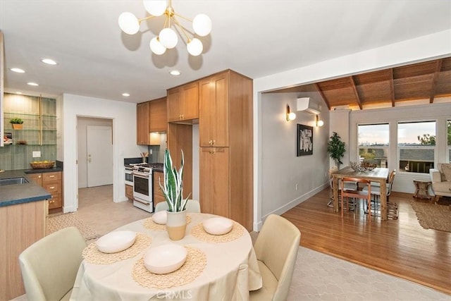 dining room with sink, a wall mounted air conditioner, an inviting chandelier, light hardwood / wood-style flooring, and lofted ceiling with beams