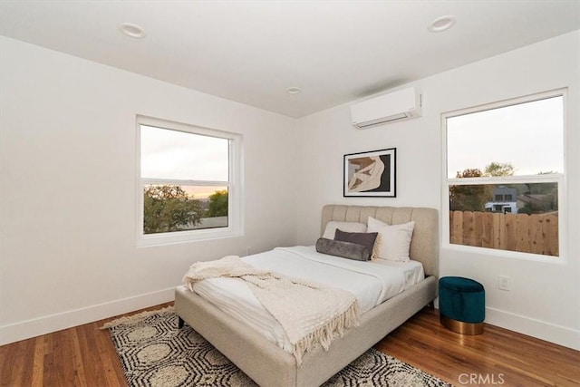 bedroom featuring hardwood / wood-style floors and an AC wall unit