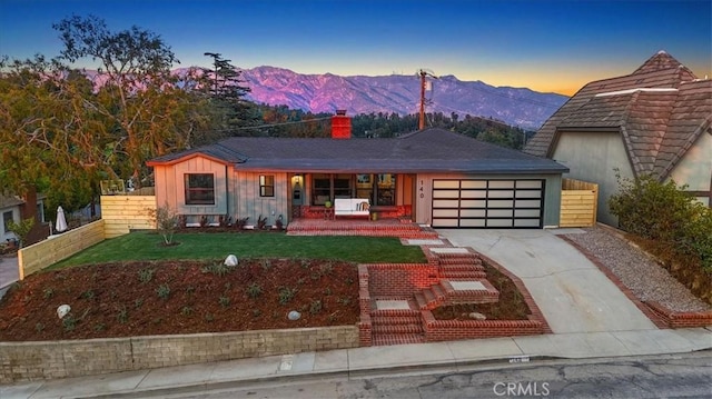 view of front of home featuring a mountain view, a yard, and a garage