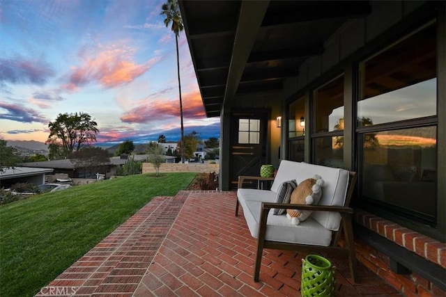 patio terrace at dusk with an outdoor hangout area and a yard