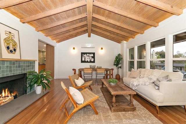 living room featuring hardwood / wood-style floors, lofted ceiling with beams, wood ceiling, and a tiled fireplace