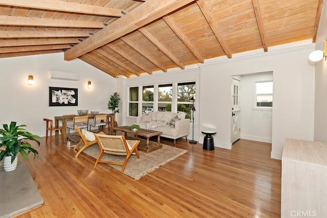 living room with a wall mounted air conditioner, vaulted ceiling with beams, hardwood / wood-style flooring, and a healthy amount of sunlight