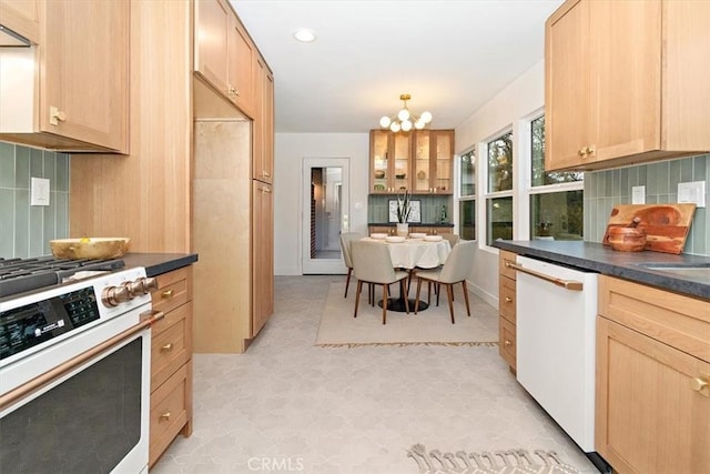 kitchen with decorative backsplash, light brown cabinets, a chandelier, and white appliances