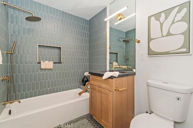 full bathroom with tile patterned floors, vanity, tiled shower / bath combo, and toilet