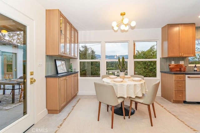 dining room featuring a mountain view, a healthy amount of sunlight, and an inviting chandelier