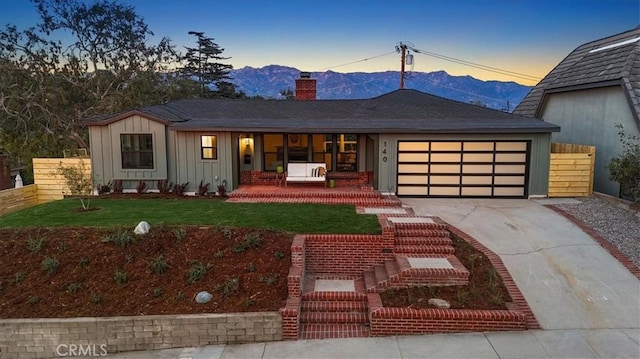 view of front facade with a mountain view, a yard, and a garage